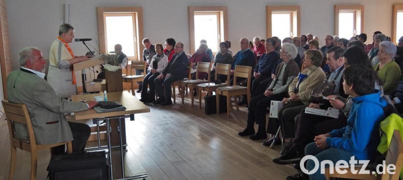 Reinhard Erös (sitzend am Tisch) wird von Martina Merk, Kolpingverbandsvorsitzende Tirschenreuth, begrüßt. Bild: Bühner