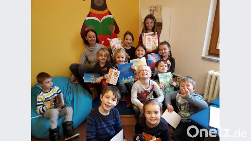 Stolz präsentieren die Vorschulkinder des Kinderhauses Hl. Geist zum Abschluss ihre Bücherei-Fuchsurkunde und die ersten ausgeliehen Bücher. Bild: exb