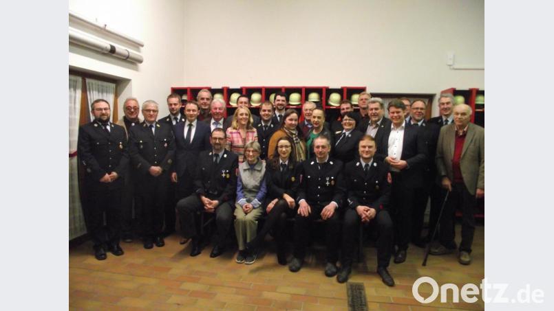 Die Ehrengäste gratulieren den Geehrten und dem neugewählten Vorstand der Muglhofer Feuerwehr. Bild: ror