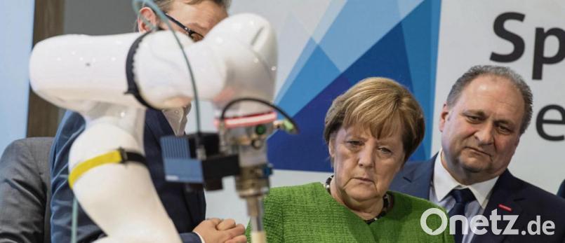 Bundeskanzlerin Angela Merkel (CDU) lässt sich nach dem Spitzengespräch der Deutschen Wirtschaft am Rande der Internationalen Handwerksmesse 2019 einen kollaborationsfähigen Roboterarm zeigen. Im Hintergrund steht Hans Peter Wollseifer, Präsident des Zentralverbandes des Deutschen Handwerks. Bild: Peter Kneffel/dpa