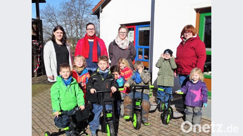 Die Kinder nahmen die neuen Fahrzeuge, die die Elternbeirätinnen um Vorsitzende Magdalena Reindl (hinten, Dritte von links) mitgebracht hatten, gleich in Beschlag. Kindergarten-Leiterin Kerstin Dilling (rechts) dankte für die Spende. Bild: hl