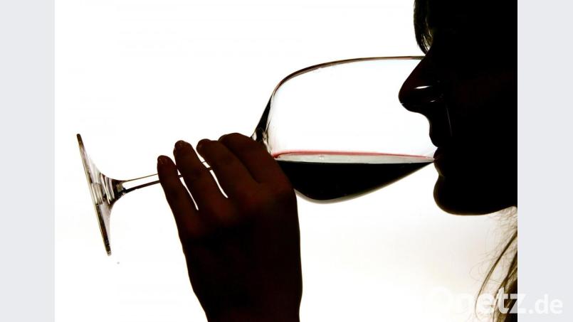 Symbolbild: Eine Frau trinkt aus einem Rotweinglas. In einem italienischen Ortschaft ist Wein anstatt von Wasser aus der Leitung geflossen. Bild: Gero Breloer/dpa