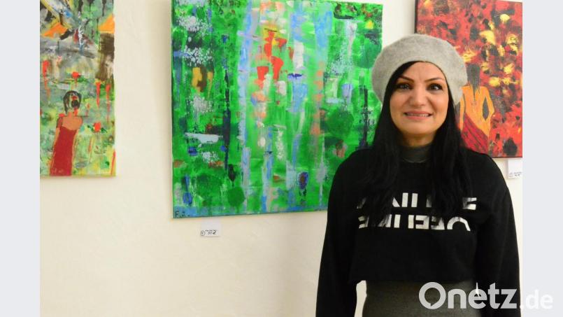 Farzaneh Jampouri vor ihren Bildern in der Regionalbibliothek. Die Künstlerin befasst sich vor allem mit Frauenthemen. Bild: Kunz