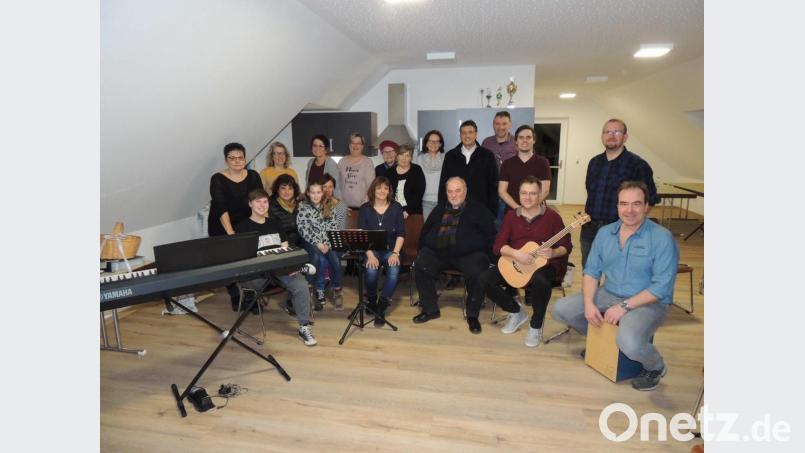 Musik und Gesang unter dem Dach erklingt künftig im Obergeschoss des Hüttner Kindergartens. Bürgermeister Edgar Knobloch (stehend, Vierter von rechts) übergibt den neuen Probenraum. Sabine Braun (sitzend, Vierte von rechts) dankt im Namen der Chöre. Bild: mor