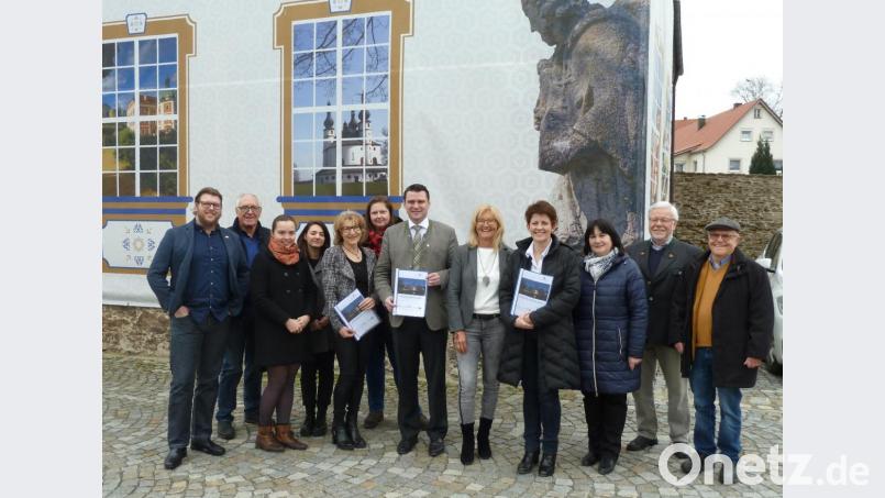 Die Fassade des Centrum Bavaria Bohemia weist auf das Projekt „Barockes Kulturerbe erleben“ hin. Die Jahresbilanz 2019 lässt die Verantwortlichen um CeBB-Leiterin Veronika Hofinger (ab Vierte von rechts), Trägervereinsvorsitzende Irene Träxler, Kuratoriumsvorsitzender Landrat Thomas Ebeling und die CeBB-Mitarbeiter Ivana Danisch, Susanne Setzer, Veronika Kaštánková (EU-Freiwilligendienst), Veronika Krístková, Erich Schlicker und David Vereš strahlen. Auch die beiden Vorsitzenden der Kulturstiftung Bavaria Bohemia, Hans Eibauer (von rechts) und Rudolf Ebenth, sowie Bürgermeisterin Birgit Höcherl freuen sich über die gute Entwicklung. Bild: Portner