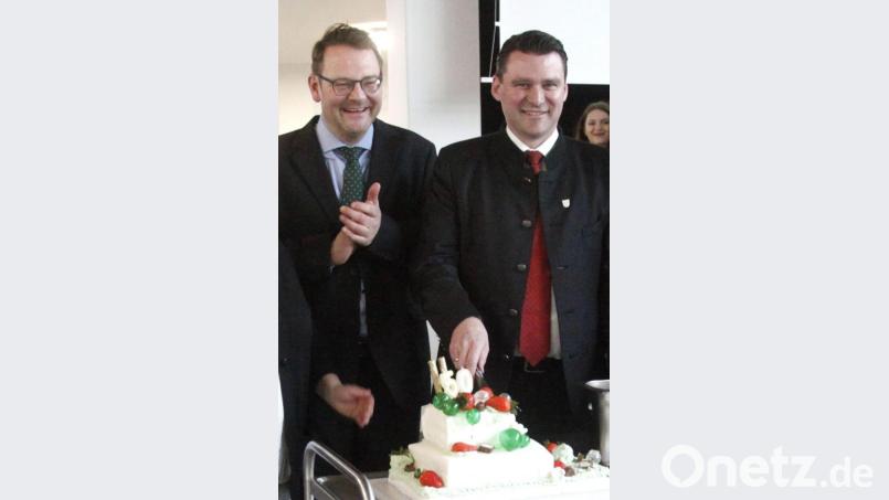 Landrat Thomas Ebeling (rechts) und Schulleiter Michael Völkl (links) schnitten die Geburtstagstorte an. Bild: Hirsch