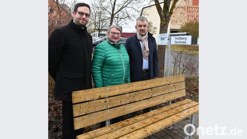 Pfarrer Dominik Mitterer, Waltraud Lobenhofer und Bürgermeister Roger Hoffmann stellen das neue Mitfahrerbanklerl bei der katholischen Kirche St. Michael vor . Mit der Tafel „Traßlberg Dorfmitte“ wird angezeigt, dass man gerne nach Traßlberg mitfahren würde. Bild: gf