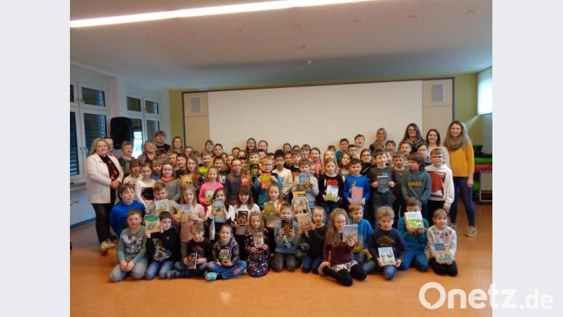Stolz präsentieren die Schüler der Winklarner Grundschule ihre Bücher, die ihnen die Vertreter des Elternbeirates (rechts) gespendet haben. Die Lehrkräfte (links) bedankten sich für das Geschenk. Bild: amö