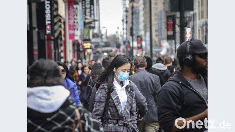 Alles andere als heile Corona-Welt in den USA: Eine Passantin trägt einen Mundschutz in New York. Die US-Notenbank hat wegen der sich abzeichnenden wirtschaftlichen Auswirkungen ihren Leitzins überraschend um einen halben Prozentpunkt gesenkt. Bild: Bebeto Matthews/AP/dpa