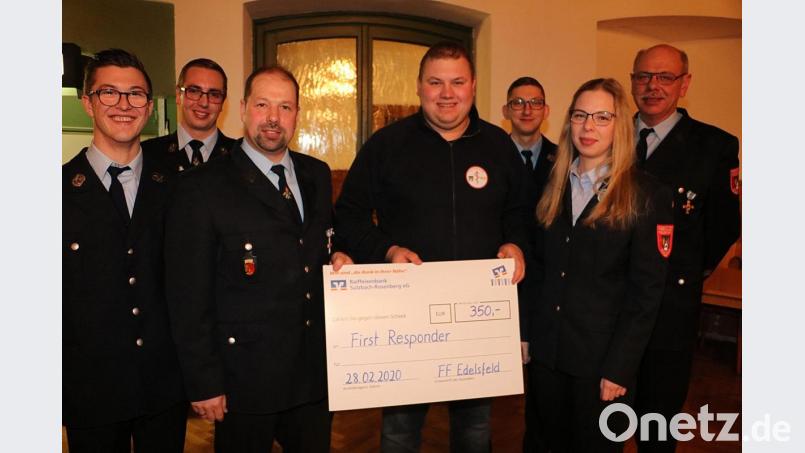 Scheckübergabe durch den Vorsitzenden der Feuerwehr Edesfeld, Alexander Luber, an Manfred Rupprecht von den First Respondern. Mit im Bild Aktiven der Rettungsleute und der Feuerwehr. Edelsfeld Bild: gru