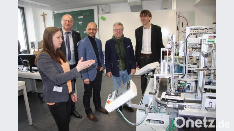 Silke Huber (links) erklärte Schulleiter Thomas Metzler, Toni Dutz, Alfred Scheidler und Hermann Körner (von rechts) das verkleinerte Modell einer Produktionsstraße, wo Handyschalen geprüft bzw. aussortiert werden. Bild: wro
