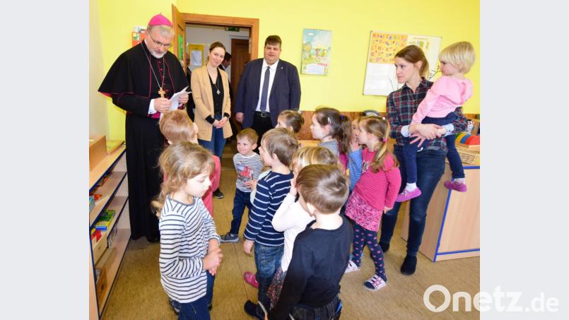 Die Mädchen und Buben der Kindertagesstätte St. Vitus suchten die Nähe zum Bischof, beobachtet von der Leiterin der Einrichtung, Sabrina Skibbe, und Erzieherin Sandra Schmidt, mit einem Kind am Arm. Bild: no