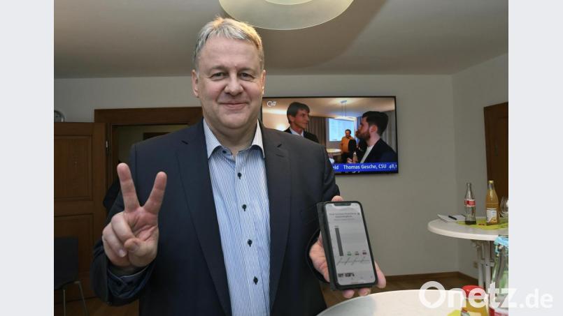 Als die größte Anspannung vorbei ist, lässt sich der wiedergewählte Landrat Richard Reisinger sogar auf ein Scherzchen mit den Fotografen und Kameraleuten im Landratsamt ein: Mit dem Victory-Zeichen kommentiert er das Ergebnis, das er per Handy angerufen hat. Bild: Petra Hartl