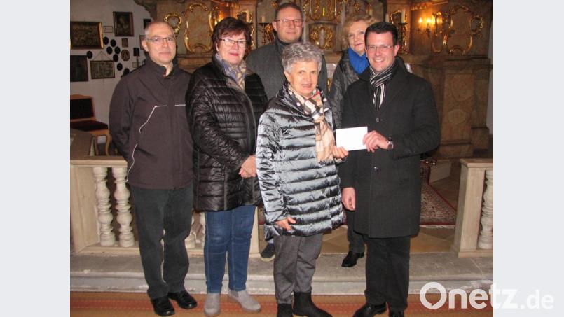 Rita Bayer (vorne links) übergibt an Präses Thomas Kohlhepp (vorne rechts) und der Vorstandschaft vom Förderverein der St.-Moritzkirche eine Spende aus dem Erlös der „Atempause für die Seele“ vom Vorjahr. Bild: knh