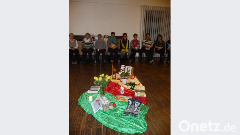 Frauen versammelten sich in einem großen Stuhlkreis rund um die Mitte, welche Bezug auf das Partnerland Simbabwe nahm. Bild: exb