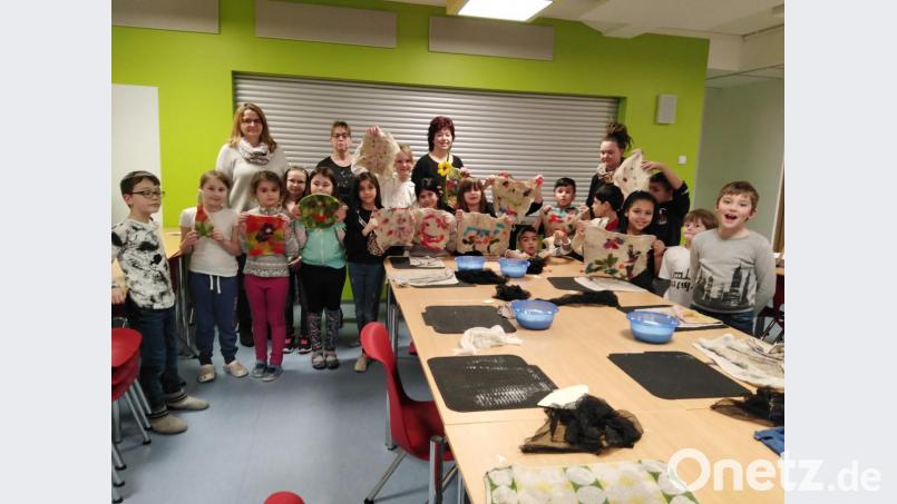 Die Kinder der Offenen Ganztagsschule zeigen stolz ihre selbst gefilzten Sachen. Angelika Trummer (hinten, Mitte) freut sich zusammen mit dem Betreuerteam mit ihnen. Bild: gpa