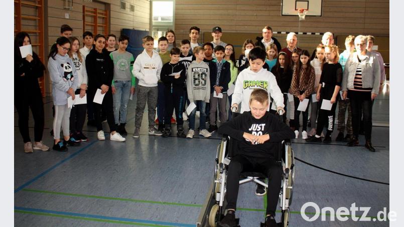 Mit dem Rollstuhl durch einen Parcours zu fahren, ist gar nicht so leicht. Die anderen Schüler schauen sich das schon mal an. Bild: R. Kreuzer