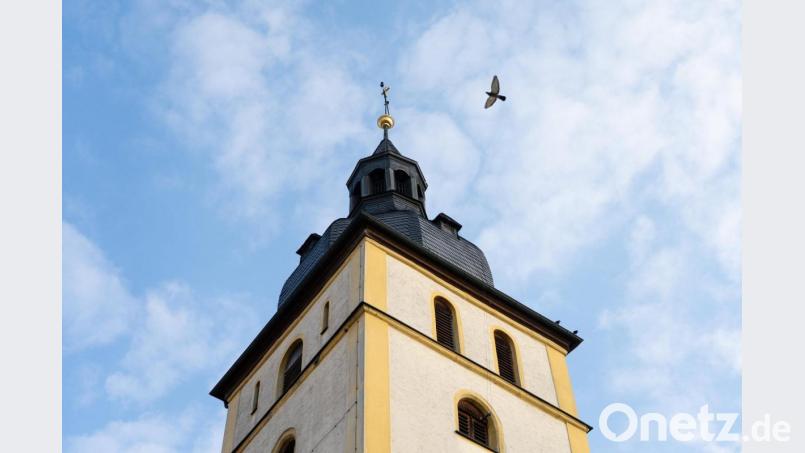 Eine Taube kreist über der Kirche St. Jakob im Ortszentrum von Mitterteich. Der Ort im Landkreis Tirschenreuth steht derzeit im Mittelpunkt der Corona-Berichterstattung. Bild: Nicolas Armer/dpa