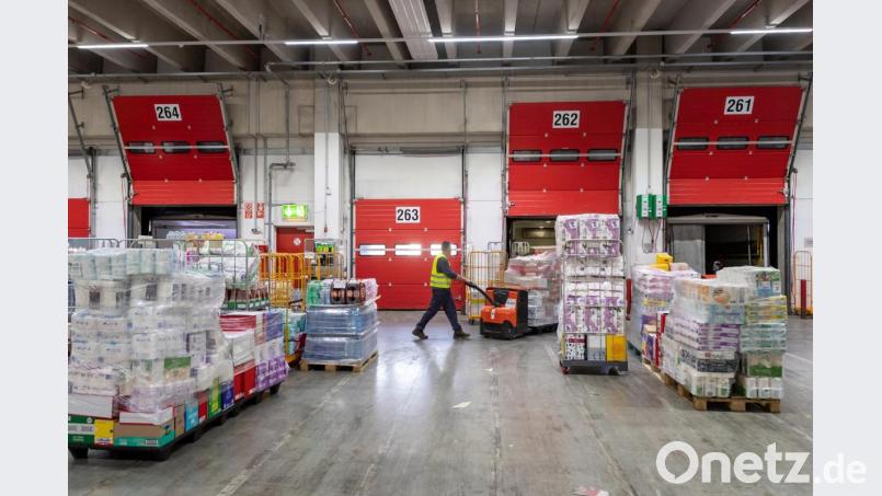 Ein Mann schiebt eine mit Waren bepackten Palettenheber durch das Zentrallager REWE Süd. Foto: Peter Kneffel/dpa/Symbolbild Bild: Peter Kneffel