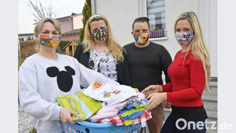 Katrin Hartwich (von links) überreicht Bianca Pröm, Michael Härtl und Melissa Burkhard von der Facebook-Gruppe „Corona Nachbarschaftshilfe Weiden“ einen Korb mit Stoff. Daraus wollen einige Gruppenmitglieder Mundschutzmasken nähen. Sie sind lediglich ein Spritzschutz. Vor einer Ansteckung mit dem Coronavirus schützen diese Masken nicht. Bild: Petra Hartl