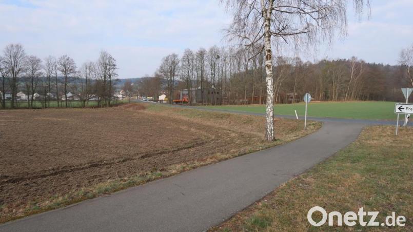 Noch in diesem Jahr soll der Lückenschluss eines Bürgersteigs/Gehweges vom Feuerwehrhaus (hinten, Mitte) zum bereits vorhandenen Wander- und Radweg von der Schlossbrauerei Friedenfels kommend (vorne) erfolgen. Die nur rund 150 Meter lange fehlende Verbindung ermöglicht Radfahrern, Wanderern, Spaziergängern und Kindern einen sicheren Verbindungsweg auch zum Freibad. Bild: bsc