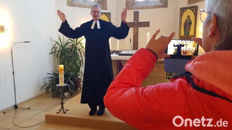 Für die Online-Andachten lässt sich Pfarrer Uwe Markert von seiner Frau in der Rosenberger St.-Johannis-Kirche mit dem Smartphone filmen. Bild: exb