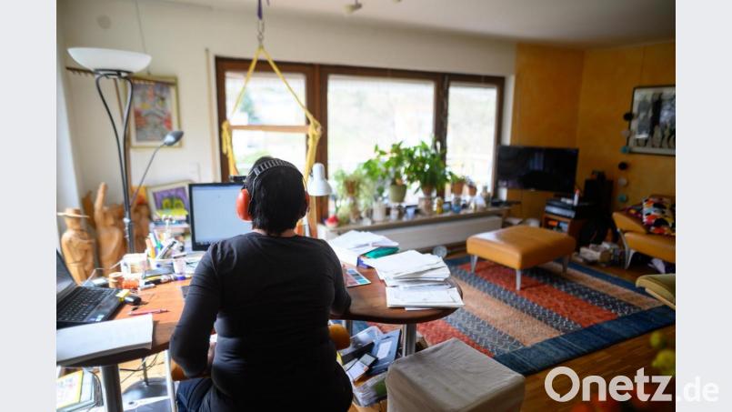 Eine Frau arbeitet mit Hörschutz im Homeoffice. Um die Ausbreitung des Coronaviruses zu verlangsamen, arbeiten viele Arbeitnehmer und Arbeitnehmerinnen von zu Hause aus. Bild: Sebastian Gollnow/dpa