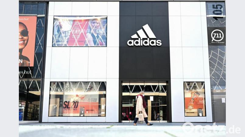 Eine Frau geht an einem Adidas-Store vorbei. Foto: Arne Dedert/dpa Bild: Arne Dedert