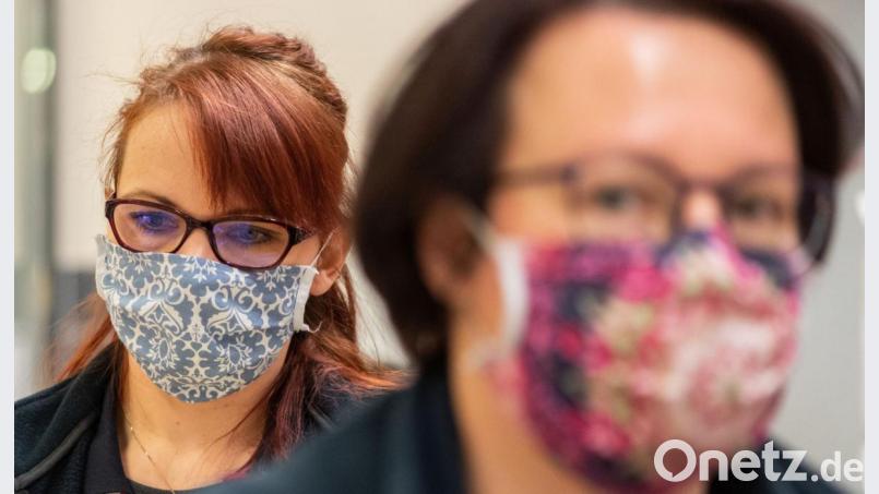 Mitarbeiterinnen in einem Supermarkt tragen Schutzmasken. Bild: Robert Michael/dpa