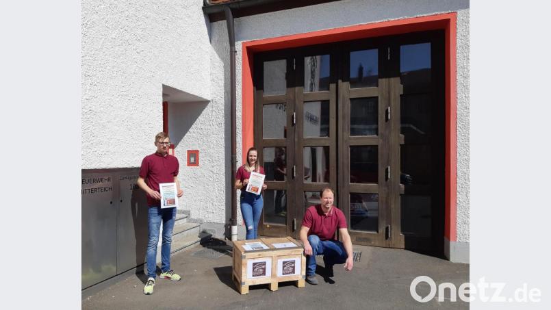 Vor dem Gerätehaus hat die Jugendfeuerwehr eine Kiste zum Einwerfen der Bilder aufgestellt. Jugendwart Johannes Schmid, Carolina Grabis und Zweiter Jugendsprecher Max Rasp (von rechts) hoffen auf eine rege Teilnahme. Bild: Jugendfeuerwehr Mitterteich/exb