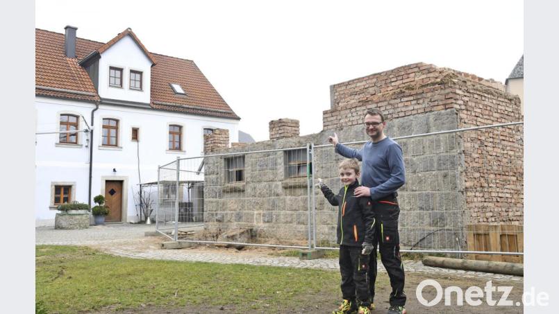 Michael Lang deutet mit Sohn Korbinian auf die Mauerreste des ehemaligen Kuhstalls, auf denen er einen neuen Stadl für ein zusätzliches gastronomisches Angebot neben der Zoigstube "Brucksaler" baut. Bild: Petra Hartl