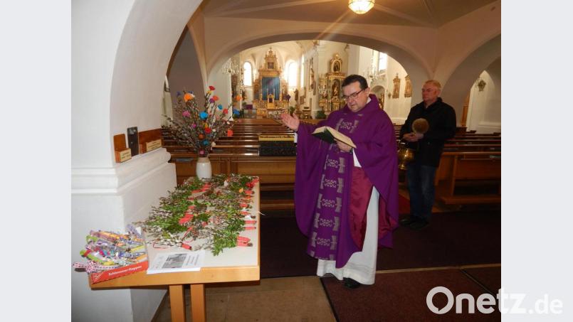Pfarrer Konrad Amschl weiht am Freitagvormittag in der Stadtpfarrkirche Bärnau die Palmbüschel, Kreuzchen und Kränze. Mesner Werner Jobst (rechts) trägt das Weihwasser. Bild: Maria Wagner/exb