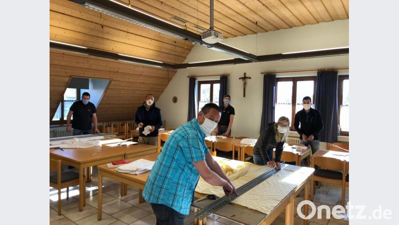 Im Schnaittenbacher Feuerwehrhaus werden die Stoffbahnen für die weitere Verarbeitung vorbereitet. Bild: Michael Werner/exb