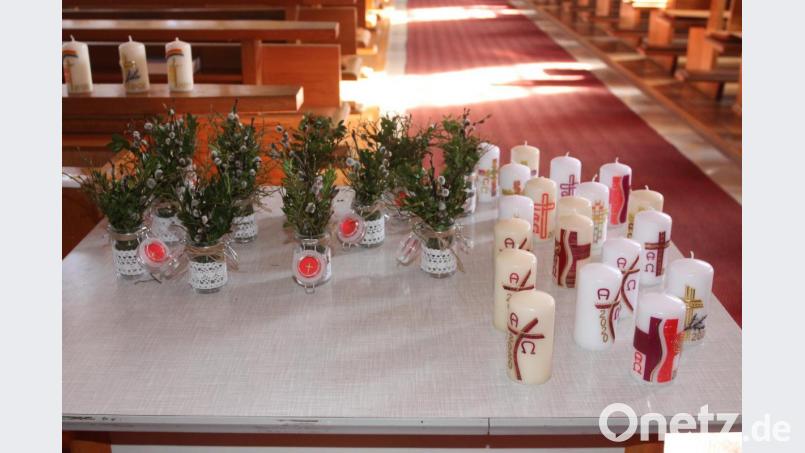 In Heimarbeit gefertigte Palmgläschen und Osterkerzen stehen in der Pfarrkirche bereit. Bild: pi