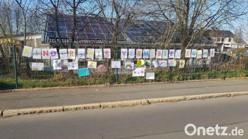 Den Schriftzug "Wir vermissen euch" am Zaun des Kinderhauses Sonnenschein in Arzberg ergänzten die Kinderhaus-Kinder ihrerseits mit Bildern, die sie übers Wochenende gemalt hatten. Bild: exb