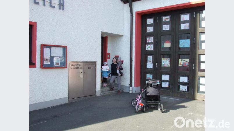 Zahlreiche Kinder haben sich schon am Malwettbewerb der Jugendfeuerwehr beteiligt, der in der vergangenen Woche gestartet wurde. Ziel ist es, 112 Glasfelder der Gerätehaustore zu schmücken. Hier im Bild eine Familie beim Abgeben eines Bildes. Bild: Feuerwehr Mitterteich/exb