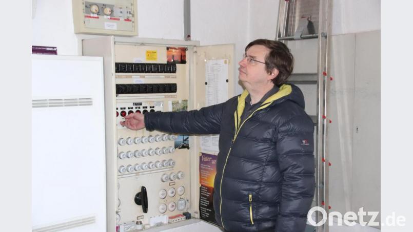 Stadtpfarrer Roland Kurz hört genau zu, um nicht zu früh die nächste Glocke einzuschalten. Die roten Lichter im großen Schaltschrank der Christuskirche zeigen, welche Glocken gerade läuten. Bild: cog