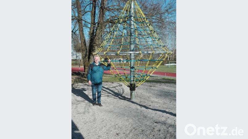 Uli Roth besichtigt das neu angebrachte Kletternetz am Drehspielgerät im Pausenhof der Grundschule. Bild: den