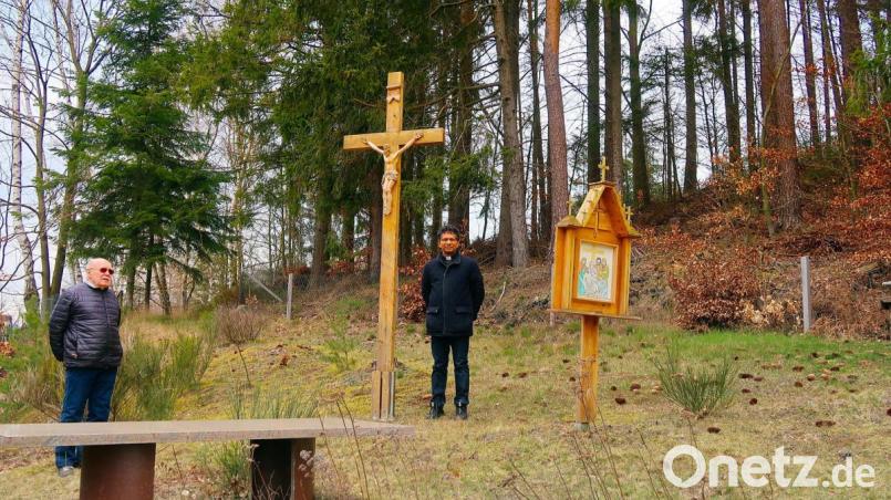 Ein großes Kreuz erwartet die Besucher am Ende des Kreuzwegs im Garten von Hans Vogl (links). Pfarrer Joseph (rechts) lobte den Künstler für sein religiöses Engagement. Bild: bsc
