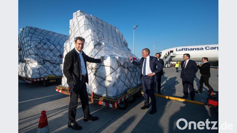 Markus Söder und Carsten Spohr, Vorstandsvorsitzender der Deutschen Lufthansa AG, stehen am Flughafen in München neben einer Lieferung von Schutzmasken. Bild: Matthias Balk/dpa