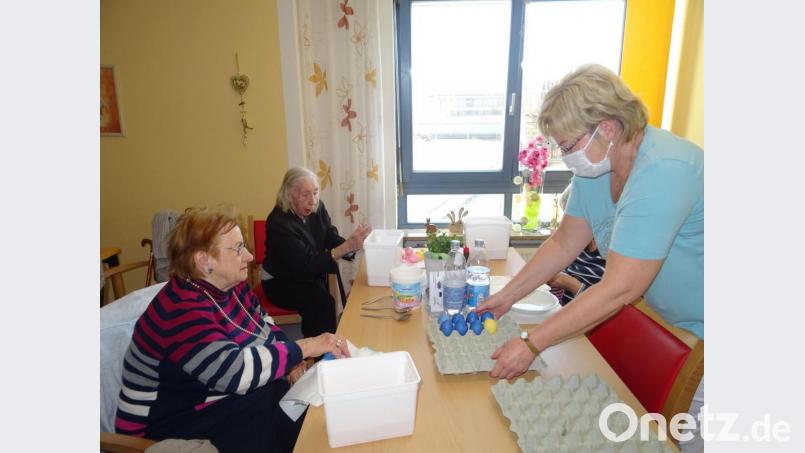 Da die Senioren in ihren Wohnbereichen wie in einer Großfamilie zusammenleben, sind Aktionen wie Ostereier färben erlaubt. Die Betreuungsmitarbeiterinnen, die dabei helfen, tragen natürlich eine Maske. Bild: Daniela Donhauser/exb