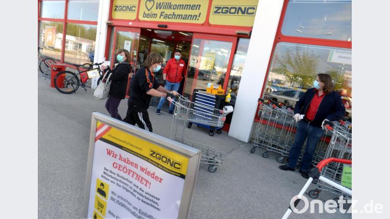 Angestellte und Kunden stehen mit Mundschutz vor dem Eingang eines Baumarkts in Österreich. Nach vierwöchiger Schließung wegen der Coronakrise haben in dem Land wieder zahlreiche Geschäfte geöffnet. Bild: Herbert Pfarrhofer/dpa