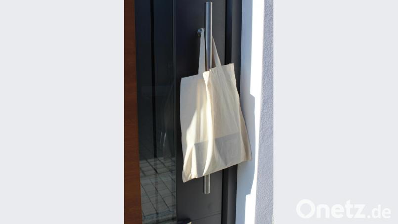 Die Bücherei-Lieferung wird kontaktlos abgegeben. Hier hängen Bücher in einem Stoffbeutel an der Haustüre. Bild: exb