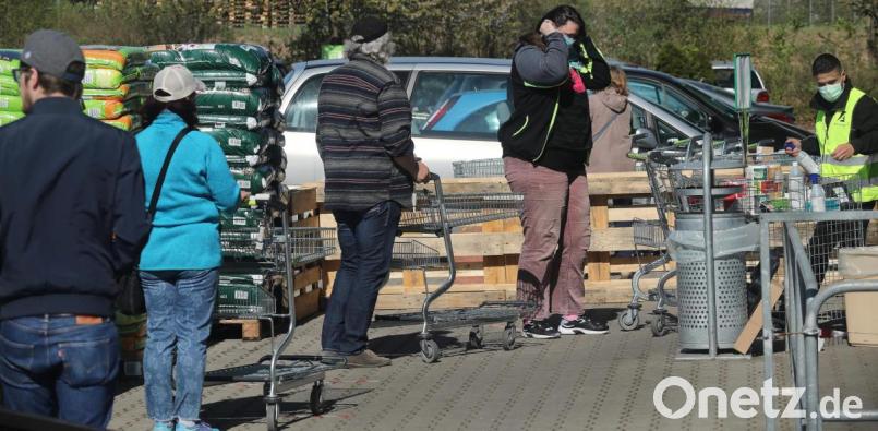 Diszipliniert standen die Kunden der Bau- und Gartenmärkte in Amberg am Montagvormittag in Schlangen vor den Geschäften, wenn es nötig war. Rechts eine Security-Kraft, die Desinfektionsmittel zur Verfügung stellte. Bild: Wolfgang Steinbacher