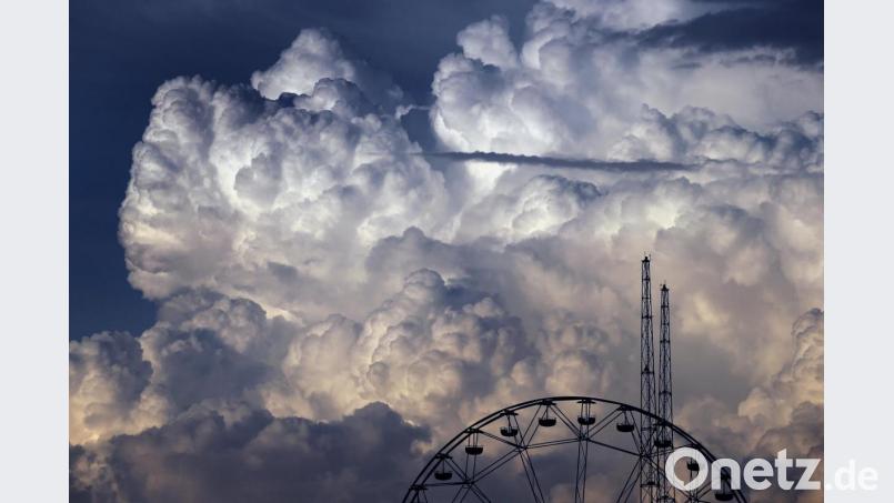 Wolken türmen sich über den Fahrgeschäften des Freizeitparks „Skylinepark“ auf. Bild: Karl-Josef Hildenbrand/dpa