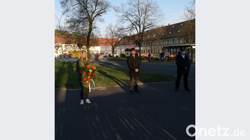 Die neugewählte Stadträtin Jana Schäffler (links) legt in Anwesenheit des Bürgermeisters Wolfgang Haberberger (Mitte) und des Vorsitzenden der Krieger- und Soldatenkameradschaft Franz Stefan (rechts) im Gedenken an die Bombardierung der Stadt am Kriegerdenkmal einen Kranz nieder. Bild: ow