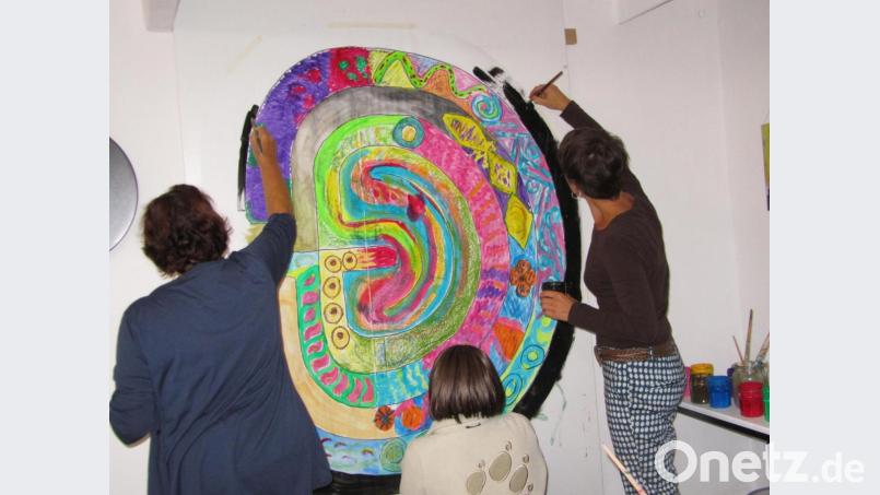 Teilnehmer einer Gruppe malen an einem „Lebenslabyrinth“. Die gemeinsame Erfahrung, dass alle auf dem Weg sind und dieser manchmal recht unübersichtliche Windungen nimmt, steht dabei im Vordergrund. Bild:  privat