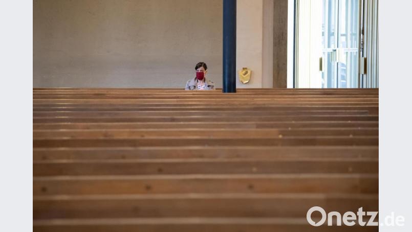 Eine Frau mit Mundschutz verfolgt einen Gottesdienst in der ansonsten fast menschenleeren St. Matthäuskirche in München. Bild: Sven Hoppe/dpa