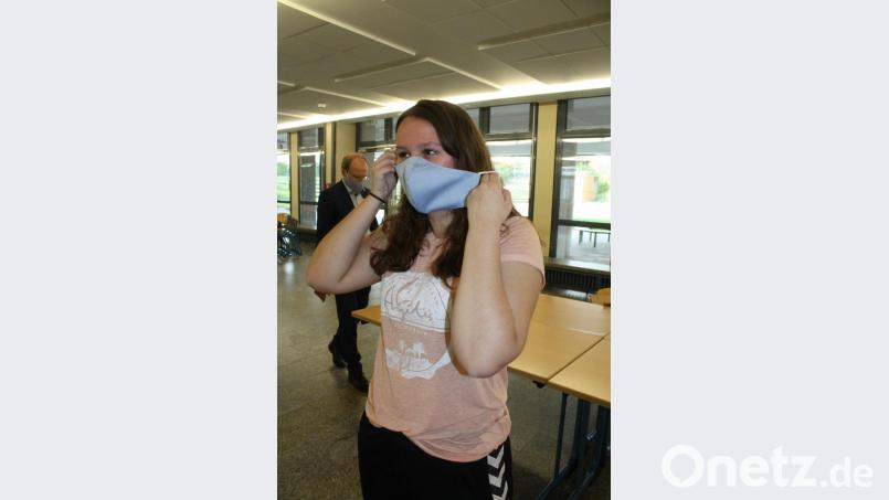 Mit wenigen Handgriffen ist die -Maske angelegt. Schulleiter Ludwig Pfeiffer (im Hintergrund) schaut bei den Ausgabeorten vorbei. Bild: lg