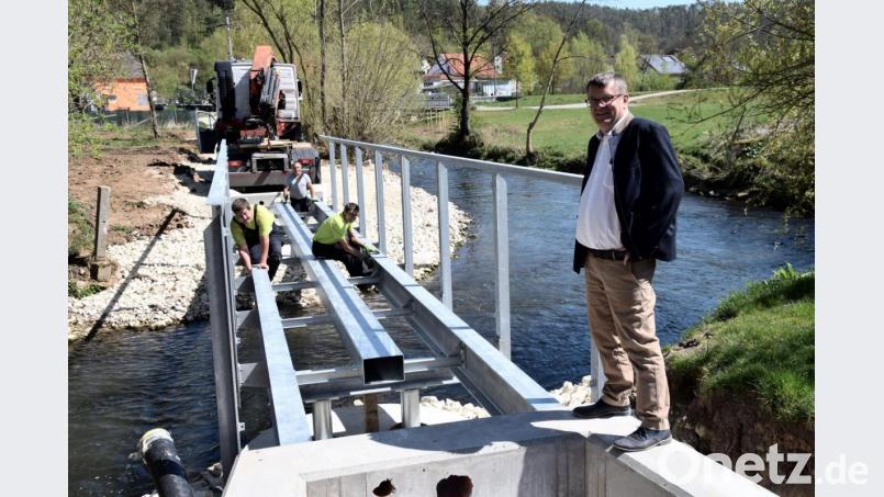 Die Stahlkonstruktion für den Lauterachsteg als weiteren Zugang zum Hammerschloss ist gesetzt. Ab Mitte Mai wird die Fußgängerbrücke nutzbar sein, sagte Bürgermeister Peter Braun (rechts) an der Baustelle. Bild: bö